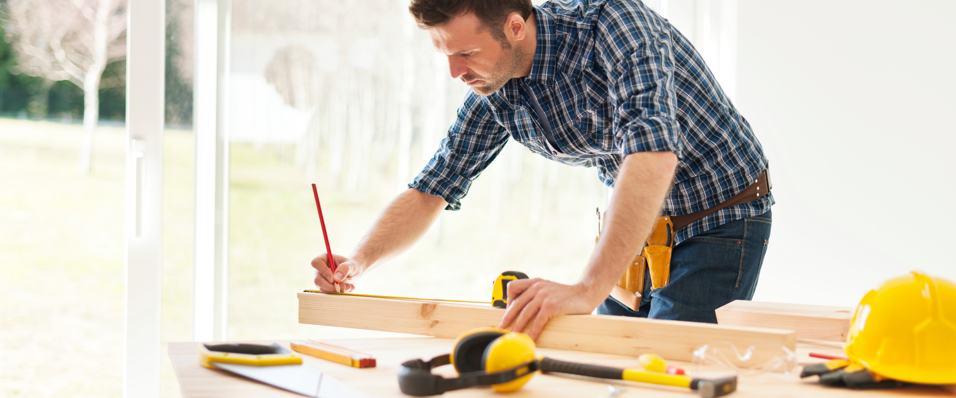 Mężczyzna robiący notatki podczas pracy z drewnem.